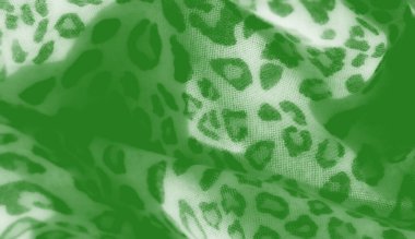 Görüntü, canlı leopar desenli yeşil bir tekstilin yakın plan çekimi. Kumaşın hassas dokusu ve yumuşak kıvrımları sanatsal cazibesine ve dokunsal kalitesine katkıda bulunur..