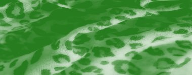 Görüntü, soyut hayvan desenleri ve kıvrımları olan çarpıcı yeşil bir kumaş. Derinlik ve zenginlik sunuyor. Moda, döşeme ya da ev dekorasyonu için ideal