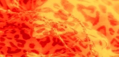 Kalın leopar benzeri lekeleri olan bulanık sarı ve turuncu kumaş, sıcaklığı ve zengin dokusuyla göze çarpan egzotik ve canlı bir desen sağlıyor, modaya uygun tekstil..