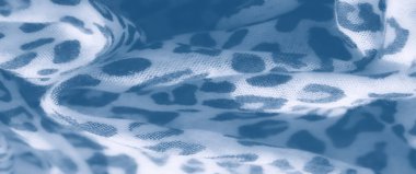 Mavi tonlu leopar desenli kumaşın ince dokuya yakın görüntüsü. Yumuşak bulanık, bu tekstil görüntüsü hayvanlardan esinlenilmiş tasarımın sakin ve narin modelini yakalar..