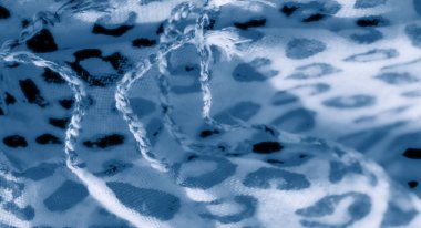 Bulanık etki, beyaz kumaş üzerindeki mavi soyut leopar beneklerini vurgular, zarafet ve sükunet saçan dokulu ve akışkan bir görünüm yaratır..