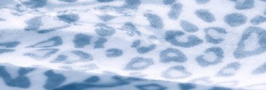 Bulanık, beyaz arka planda organik, düzensiz leopar benzeri desenlere sahip mavi renkli kumaşı vurgular. Yumuşak dokusu ve katmanlı tasarımı huzurlu ve şık bir hissi çağrıştırıyor..