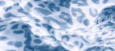 Bulanık etki, beyaz kumaş üzerindeki mavi soyut leopar beneklerini vurgular, zarafet ve sükunet saçan dokulu ve akışkan bir görünüm yaratır..