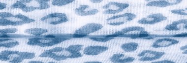 Bulanık etki, beyaz kumaş üzerindeki mavi soyut leopar beneklerini vurgular, zarafet ve sükunet saçan dokulu ve akışkan bir görünüm yaratır..