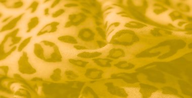 Katmanlı kareli desenli Bulanık Yeşil kumaş dokunmuş yapısını vurguluyor ve kumaşların üzerindeki ışık ve gölge karışımından derinlik ekliyor.