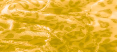 Bulanık - yumuşak, karmaşık leopar desenli sarı bir kumaşın yakın çekim görüntüsü. Işık ve doku kumaşın sıcaklığını vurgular, pürüzsüz ve lüks bir görünüm yaratır..