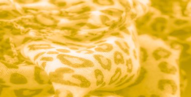 Soyut leopar desenli yumuşak, sarı bir kumaşın bulanıklığı. Kumaştaki karmaşık detaylar sıcak, dokulu bir görünüm yaratır, kıvrımlara ve renklere derinlik ve ince bir kontrastlık ekler..