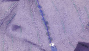 Yeşil ve mavi işlemeli bulanık lavanta tekstil ve pullar. Nazik perdeler ve ışıldayan pullar zarif, lüks bir kumaş dokusu yaratır..