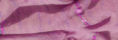 Hassas pullarla süslenmiş bulanık pembe kumaş ve dikişli desenler yumuşak, dokulu bir görünüm yaratır. Mor ipliğin ince ipuçları ve parıldayan pullar derinlik ve zarafet ekler.