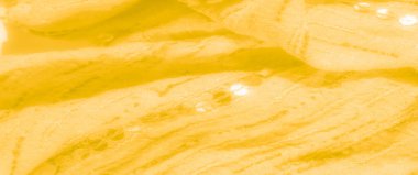 Görüntü. Yumuşak kıvrımları ve ince, karmaşık desenleri olan rahat sarı bir kumaş. Tekstilin hassas dairesel dokusunu ve sıcak, davetkar görünümünü yakından gösteriyor..