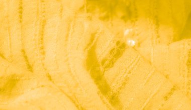 Zayıf çizgileri ve yuvarlak pullu aksanları olan karmaşık detaylı sarı kumaş bulanıklığı, dekoratif veya moda kullanımı için yumuşak, dokulu bir arka plan yaratıyor.