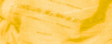 Detaylı dikişleri ve ışıldayan pulları olan bulanık sarı kumaş. Hassas kıvrımlar ve karmaşık dokular sanatsal ve canlı bir cazibe getiriyor.