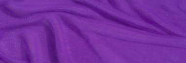 Yumuşak, rahat mor kumaşlı dinamik kıvrımlı, lüks bir doku oluşturan bir bulanıklık. Yakın çekim görüntüsü, konforlu tekstil derinliğine derinlik ekleyerek karmaşık ayrıntıları vurgular.