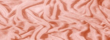 Görüntü, arka plan ve tasarım elementleri için uygun sıcaklığı ve yumuşaklığı çağrıştıran karmaşık desenleri ve dokuları gösteren katmanlı turuncu kumaşın zarif bir görüntüsü..