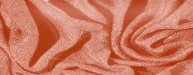 Yumuşak katlanmış turuncu kumaşın bulanıklığı, hafif kıvrımlar ve ışığı yakalayan dokulu bir yüzey, zengin, sıcak bir ortam ve rahat bir tekstil etkisi yaratıyor..