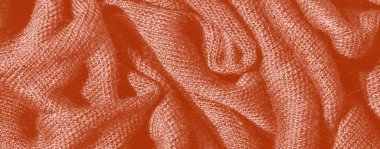 Yumuşak katlanmış turuncu kumaşın bulanıklığı, hafif kıvrımlar ve ışığı yakalayan dokulu bir yüzey, zengin, sıcak bir ortam ve rahat bir tekstil etkisi yaratıyor..