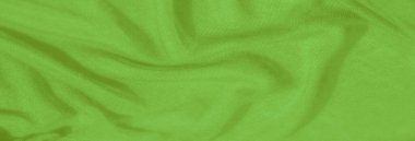 Katmanlı kareli desenli Bulanık Yeşil kumaş dokunmuş yapısını vurguluyor ve kumaşların üzerindeki ışık ve gölge karışımından derinlik ekliyor.