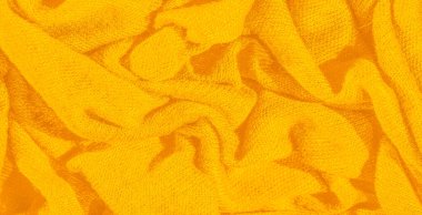Karmaşık kıvrımları olan yumuşak sarı kumaş, sıcaklık ve konfor hissi uyandırıyor, onu tekstil arka planı, ev dekorasyonu ve yaratıcı tasarım uygulamaları için ideal hale getiriyor..