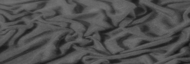 Bulanık desenli siyah kumaş yumuşak kıvrımlardan ve kırışıklıklardan oluşan karmaşık bir desen oluşturur, derinlik ve kontrastlık yaratır. Işık dokunun ince, dokuma dokusunu vurguluyor ve dokunsal bir boyut ekliyor..