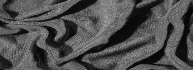 Karmaşık kıvrımlı, koyu, zengin bir kumaşın bulanık görüntüsü, katmanlı ve dokulu bir etki yaratıyor. Monokrom tonları, kumaşın sunu, dokunmuş dokusunu, derinliğini ve zarafetini vurguluyor.