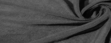 Karmaşık kıvrımları ve kıvrımları olan bulanık, koyu renkli kumaş, gölgelerin ve gölgelerin zengin bir kalıbını oluşturuyor. Kumaşın dokusu tek renkli tonlar tarafından vurgulanır.