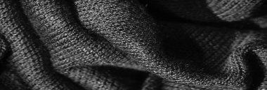 Karmaşık kıvrımlar ve dokumalar gösteren, dokulu yüzeyi olan rahat, siyah bir kumaş. Her kıvrım, kumaşın kalitesini ve derinliğini vurgulayan zengin, tek renkli bir desen yaratır.