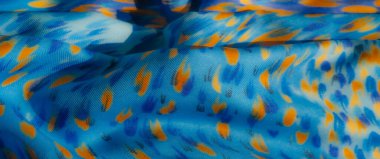 Bulanık mavi kumaş, parlak sarı ve mor noktalar, soyut bir desen oluşturuyor. Kumaşın dokusu ince kıvrımlarla büyütülmüş, zarif bir...