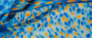 Sarı ve mor noktaların sanatsal dağılımına sahip bulanık mavi kumaş görüntüsü, canlı ve soyut bir his ekliyor. Sıvı dokuyu güçlendirir.,