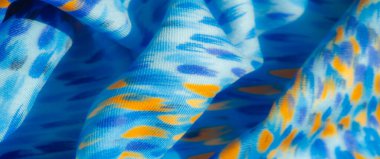 Mavi kumaş karışımı turuncu ve mavi çizgiler, yumuşak ve zarif kıvrımlar halinde akıyor. Dinamik renk deseni, kalın ve ince tonlarla görsel olarak büyüleyici..