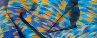 Sarı ve mor renkli canlı bir karışımla bulanık mavi kumaş. Yumuşak kıvrımlar ve dalgalanan dokular sayesinde derinlik ve görsel ilgi ekleyen canlı bir şablon oluşturuyor..