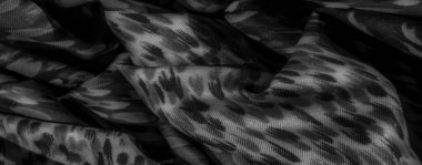 Üst üste binen desenler ve nazik kıvrımlarla gri tonda bulanık kumaş. Şekillerin soyut düzeni derinlik ve hareket ekler, dekoratif için idealdir.