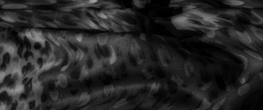 Gri tonda bulanık kumaş doğal ve soyut şekillerin karışımını andıran karmaşık bir desen. Yumuşak kıvrımlar ışığı vurgular ve tekstil boyunca koyu kontrastlar.