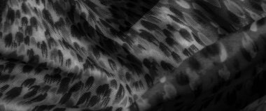 Bulanık siyah beyaz kumaş ve soyut şekiller. Yumuşak kıvrımlı katmanlı bir görüntü yaratıyor. Gri tonlama derinlik sağlar, kumaşa modern, sanatsal bir his verir..