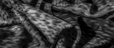 Görüntü. Bu gri pullu kumaş, yumuşak akışkan desenli, zarafet yayıyor. Hassas monokrom tasarımı yumuşak gölgelerle zenginleştirilir, ona lüks bir görünüm verir..