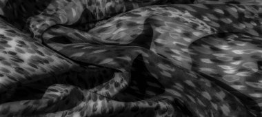 Görüntü. Bu gri ölçekli kumaş, görsel bir etki yaratan dinamik soyut desenler içerir. Yumuşak ve pürüzsüz, ince dokuları karmaşık tek renkli temayla birleştirir..