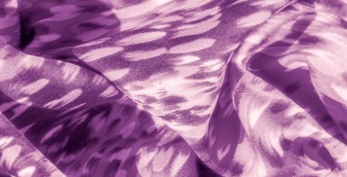 Mor kumaşın üzerindeki bulanık ışık ve gölge yumuşak dokular ve akış çizgileriyle soyut bir etki yaratıyor. Kumaşın hareketi, sanatsal cazibesini artırmak için güzel bir şekilde yakalıyor..