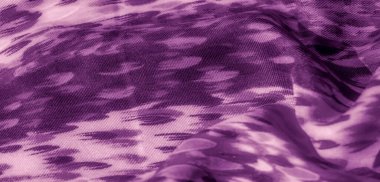 Kıvrımlı, mor renkli, kıvrımlı bir kumaşın bulanıklığı. Katlar yumuşak gölgeler ve röfle oluşturarak kompozisyona derinlik ve akıcılık hissi katıyor..