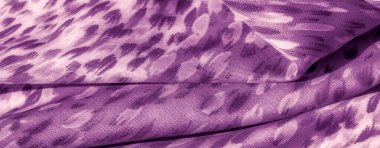 Yumuşak desenler ve yumuşak kıvrımlarla süslenmiş narin mor kumaş bulanıklığı. Kumaşın dokusu ve gölgesi dinamik ama uyumlu bir görsel deneyim yaratır..