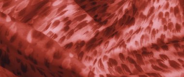 Hassas ve soyut desenli kırmızı kumaş bulanıklığı. Akan kıvrımlar boyunca ışık ve gölgenin etkileşimi kumaşın dokusunu vurgular, sıcaklık ve stil duygusu yaratır..