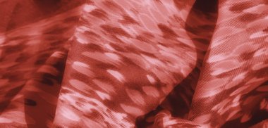 Soyut desenleri olan kırmızı desenli bulanık kumaş, yumuşak ve akıcı kıvrımlar sergiliyor. Kumaş tasarımı yumuşak bir parıltıyla ılık bir tonu yakalar, derinlik ve doku ekler..