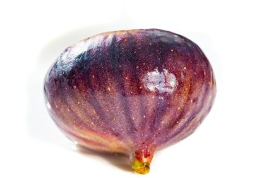 Cildinde mor renkli canlı bir incir ve parlak bir arkaplanda sarı bir parlak ışık sergilenir. İncir 'in parlak dokusu olgunluğunu vurgular..