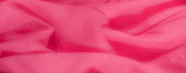 Zengin, koyu pembe kumaştan oluşan bulanık, nazikçe katlanmış ve katlanmış, rahatlatıcı ve sıcak bir doku yaratıyor. Görüntü, tekstilin karmaşık yapısını lüks ve cezbedici bir cazibeyle yakalıyor.