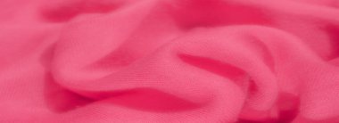 Karmaşık kıvrımları olan zengin pembe tekstil bulanıklığı dinamik ve katmanlı bir yüzey oluşturuyor. Pürüzsüz kumaş sıcak pembe bir renk yayar, yakın çekim ince dokuya sahiptir..