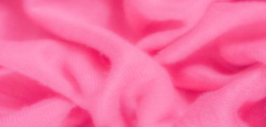 Katlanmış pembe kumaş bulanıklığı, canlı pembe bir tonu olan yumuşak ve pürüzsüz bir dokuyu vurguluyor. Nazik kırışıklıklar, arka plan için mükemmel bir ışık ve gölge oyunu yaratır..