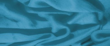 Yumuşak, pürüzsüz kıvrımlı mavi kumaş bulanık dalgalar halinde. Kalıplaşmış yüzey ve soyut form maddeye bir hareket ve zarafet hissi verir..