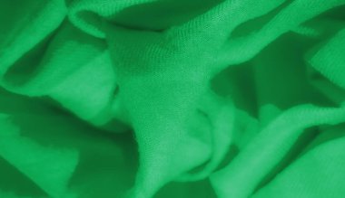 Parlak yeşil kumaş bulanıklığı, yumuşak kıvrımlar ve zarif, akıcı bir görünüm oluşturan pürüzsüz doku. Yakından bakınca, karmaşık dokuma ve renk derinliği vurgulanıyor..