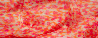 Görüntü. Bu kumaş pembe ve turuncu tonlu çiçeklerden esinlenilmiş bir tasarım sergiliyor, yumuşak ve akıcı bir doku yaratıyor. Şablon kumaşın havadar havasına ince ve şık bir dokunuş katıyor..