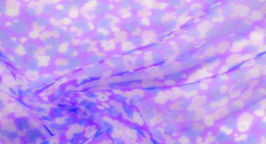 Mor ve mavi çiçekli desenlerin rüya gibi bir karışımı olan narin kumaşın bulanık dokusu yumuşak ve katmanlı bir dokuyu gösteriyor. Akan tasarım hafif, havadar bir ortam yayıyor..