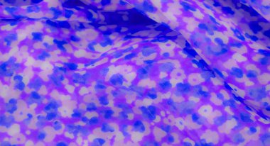 Kalın, mor ve mavi lekeli kumaş bulanıklığı soyut, çiçekten esinlenilmiş bir tasarım oluşturuyor. Hafif doku ve renk dağılımı, tekstil sanatı için mükemmel tuhaf ve havadar bir görünüm yaratıyor.