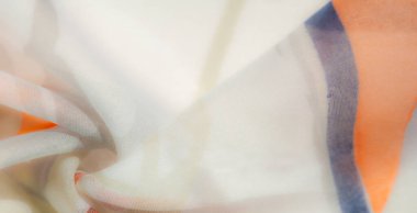 Bulanık efekt, soyut turuncu tasarımlı havadar bir kumaş gösteriyor. Hassas kıvrımlar ve nazik tonlar bunu ev dekorasyonu veya tekstil tasarım projeleri için ideal hale getiriyor..